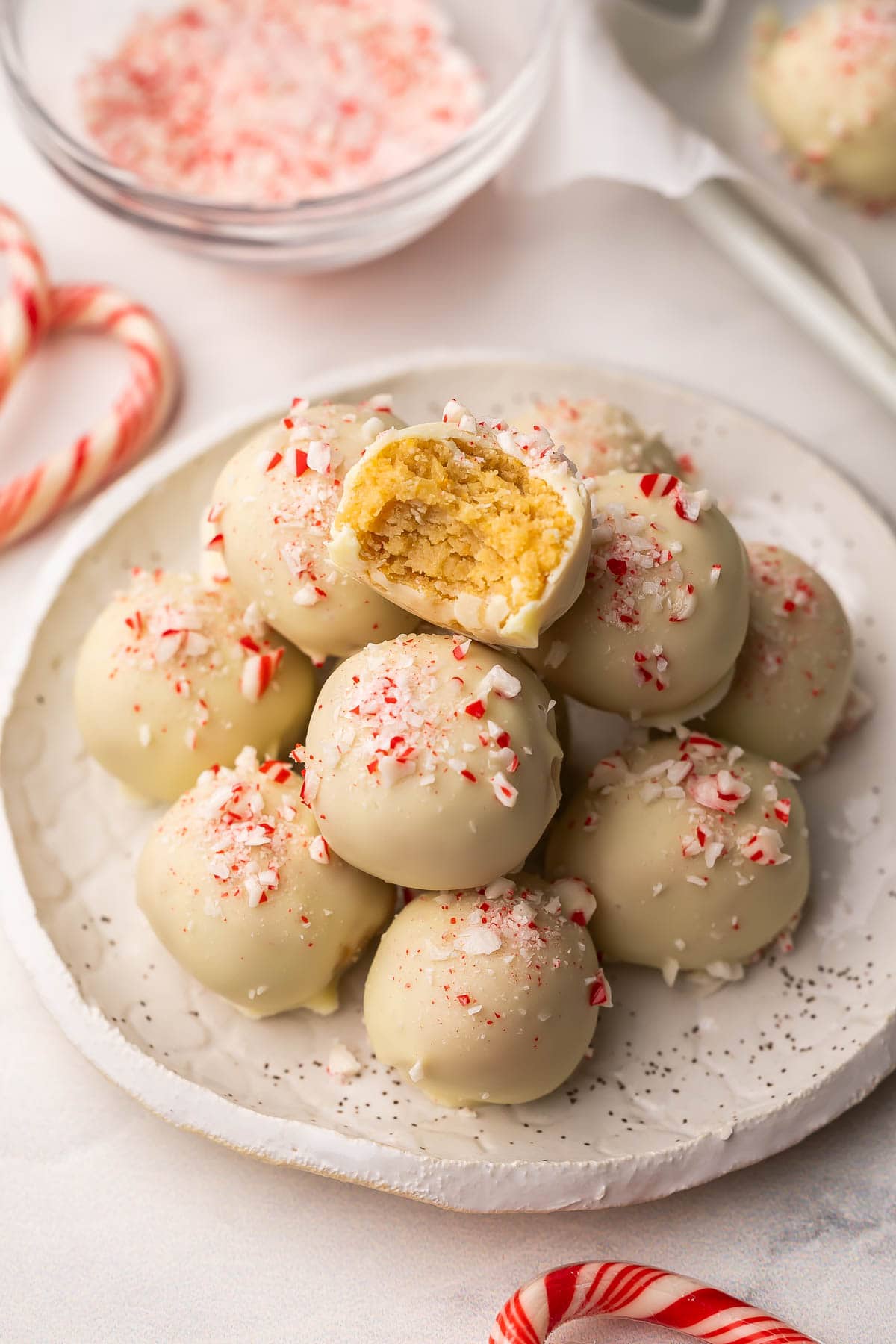 white chocolate peppermint oreo truffles on a white plate with a bite out.