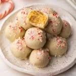 square image of a stack of white chocolate oreo truffles with a bite taken out of one.