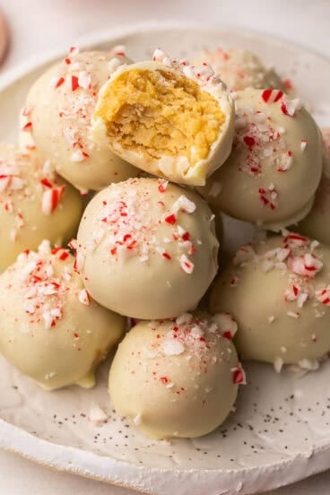 square image of a stack of white chocolate oreo truffles with a bite taken out of one.