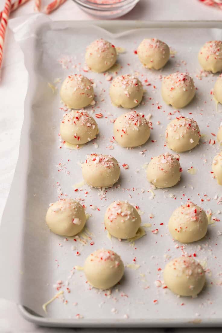 white chocolate peppermint truffles on a parchment lined baking sheet.