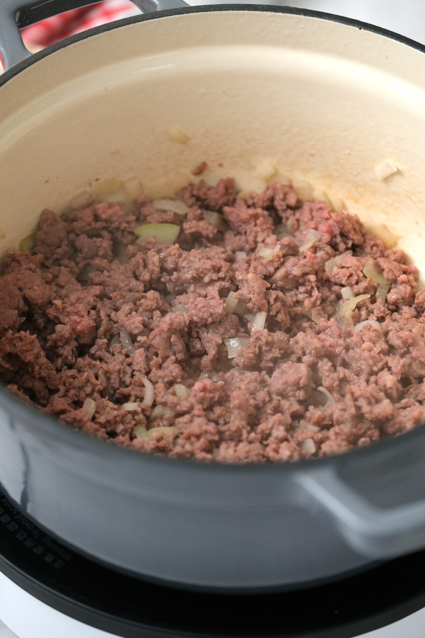 ground beef and onion cooked in pot.