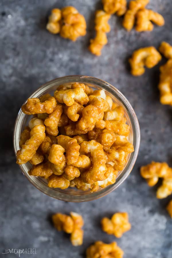 caramel puff corn in jar overhead with kernels around the jar on dark grey background