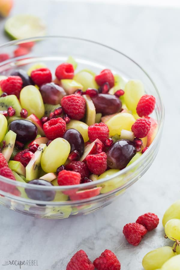 christmas fruit salad in clear glass bowl with red and green fruit