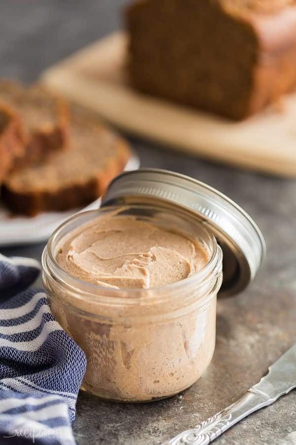 texas roadhouse cinnamon butter in a glass jar on grey background with banana bread in the background