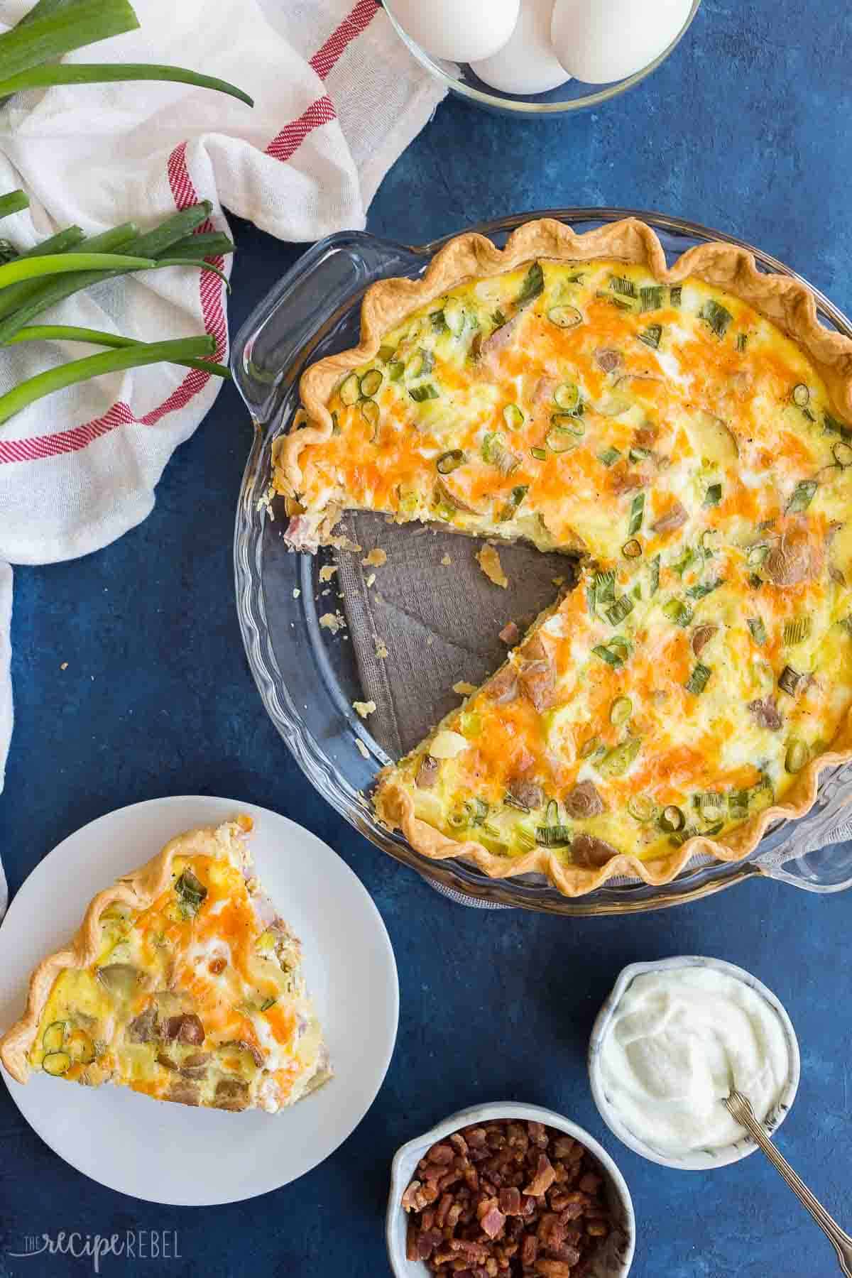 This Loaded Baked Potato Quiche is easy and full of flavor! It's the perfect easy quiche recipe for the holidays or a weeknight dinner. #breakfast #quiche #recipe | easter brunch | holiday brunch | breakfast recipes | quiche recipes | baked potatoes | easy dinner ideas overhead image of loaded baked potato quiche with one piece cut out.