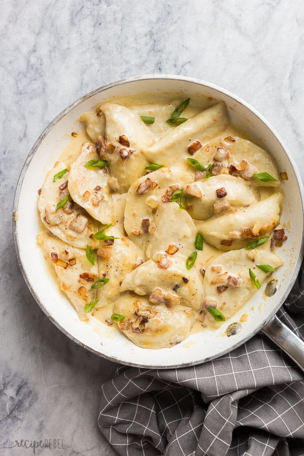 perogies recipe in white pan overhead on marble background with grey towel on the side