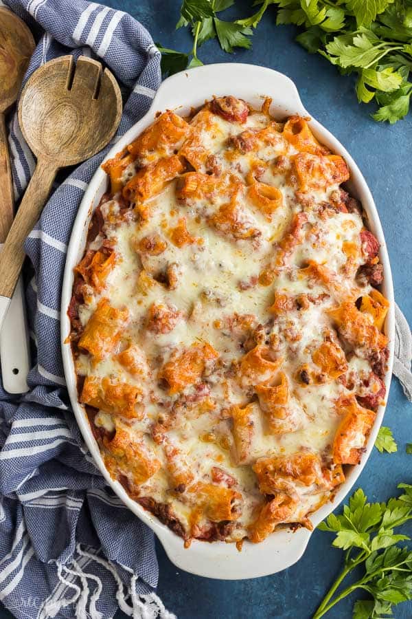 rigatoni pasta bake overhead in white baking dish on blue background