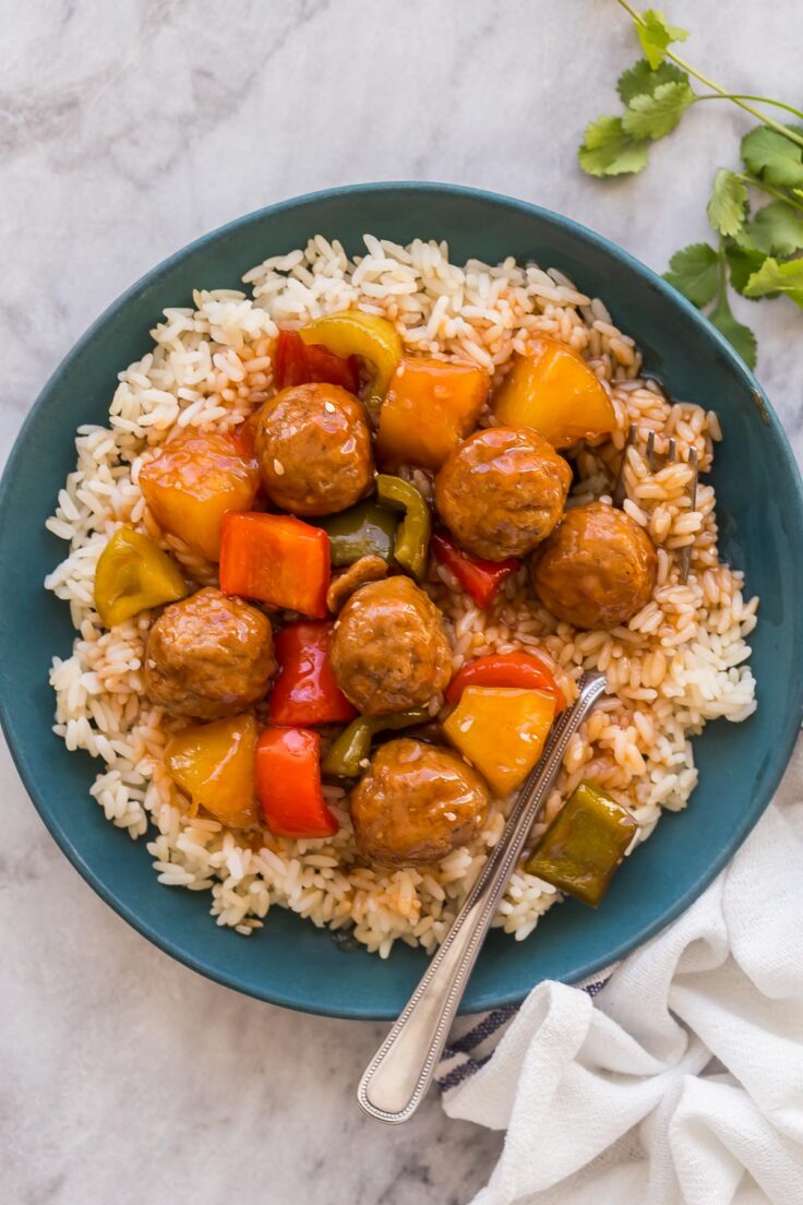 overhead image of sweet and sour meatballs on a plate of rice