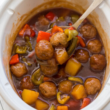 ladle scooping crockpot meatballs out of slow cooker