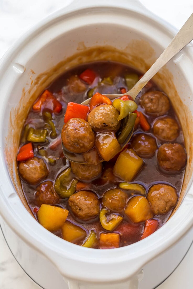 ladle scooping crockpot meatballs out of slow cooker