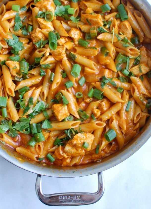 one pot enchilada pasta close up overhead with fresh parsley and green onions garnish
