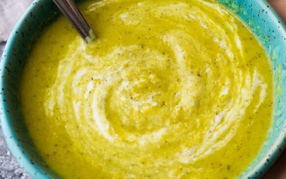 close up image of broccoli ginger soup in blue bowl