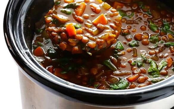 ladle scooping lentil soup out of slow cooker