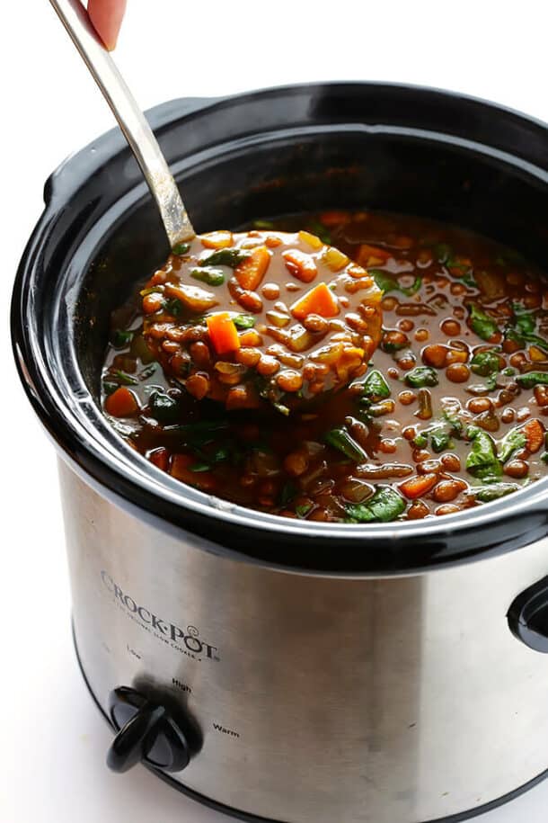 slow cooker curried lentil soup in crockpot with a metal scoop pulling some up