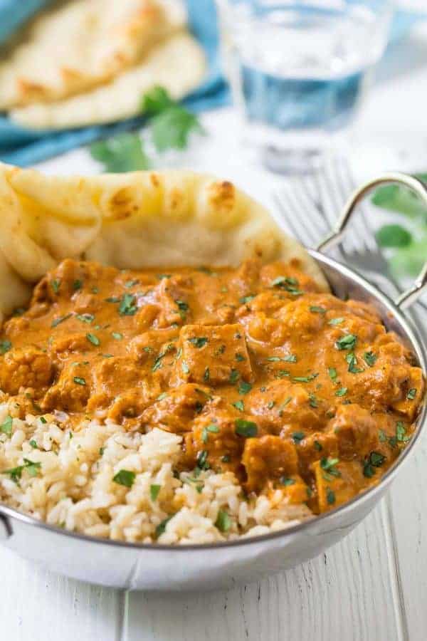 instant pot butter chicken with rice in metal bowl with naan stuck in the side