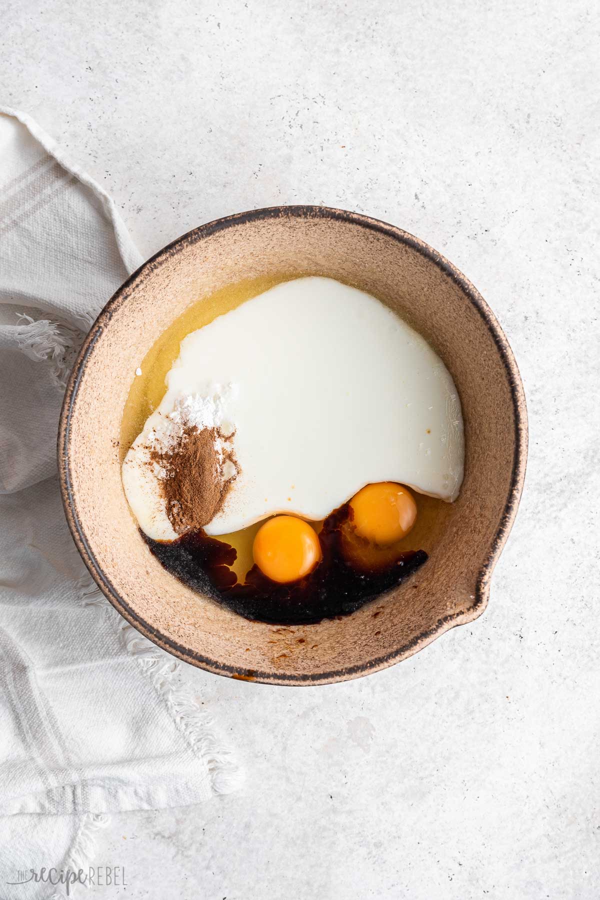 wet ingredients added to sugar and butter in bowl.