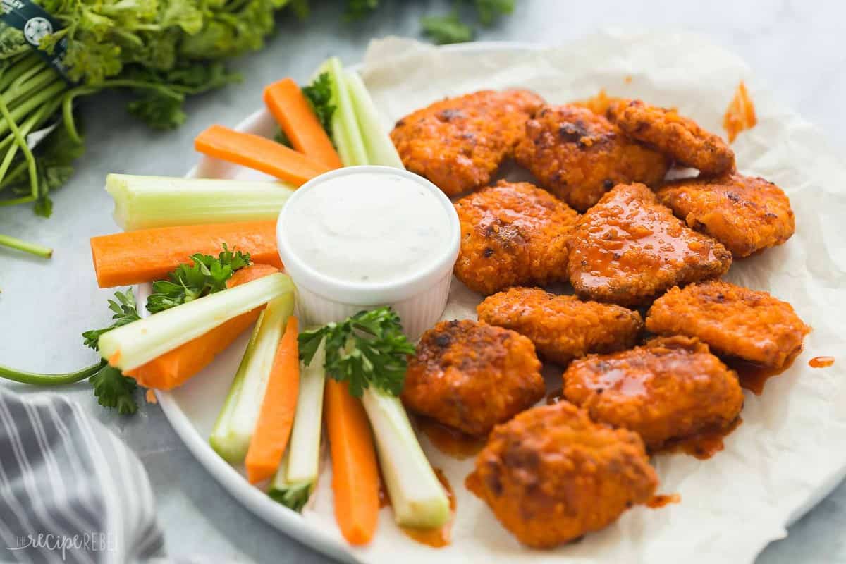 buffalo boneless chicken wings with celery and carrots and fresh parsley in the background