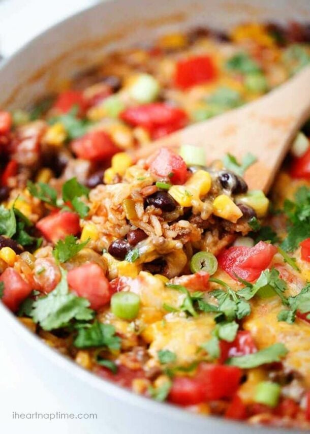 one pot burrito bowls close up with wooden spoon stuck in