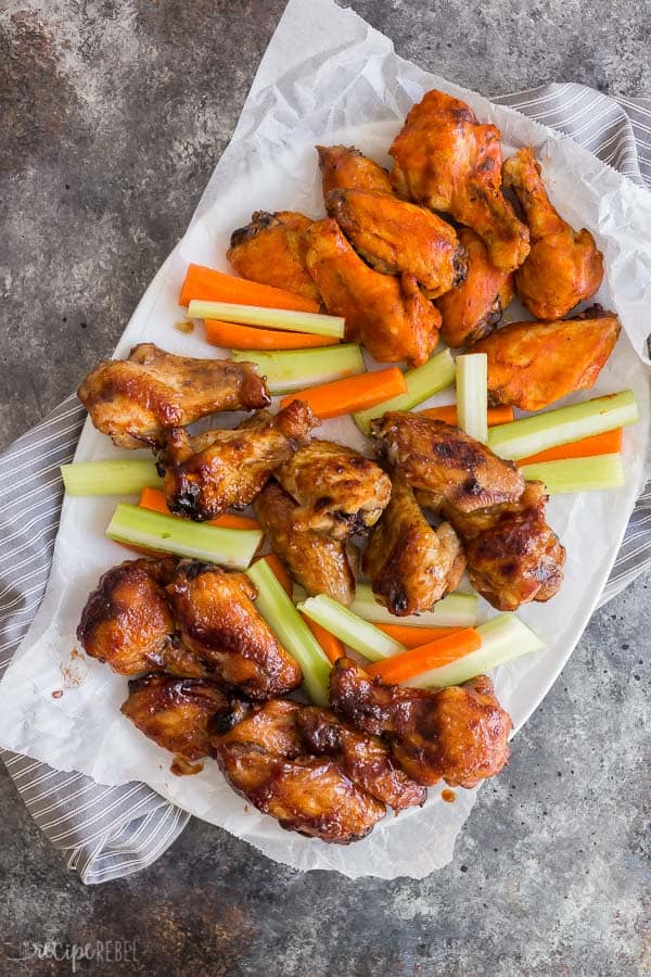 slow cooker chicken wings crockpot on platter overhead on grey background with grey towel underneath