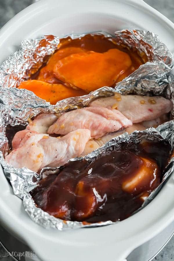 crockpot chicken wings in slow cooker with tin foil in between the different flavors buffalo bbq honey garlic