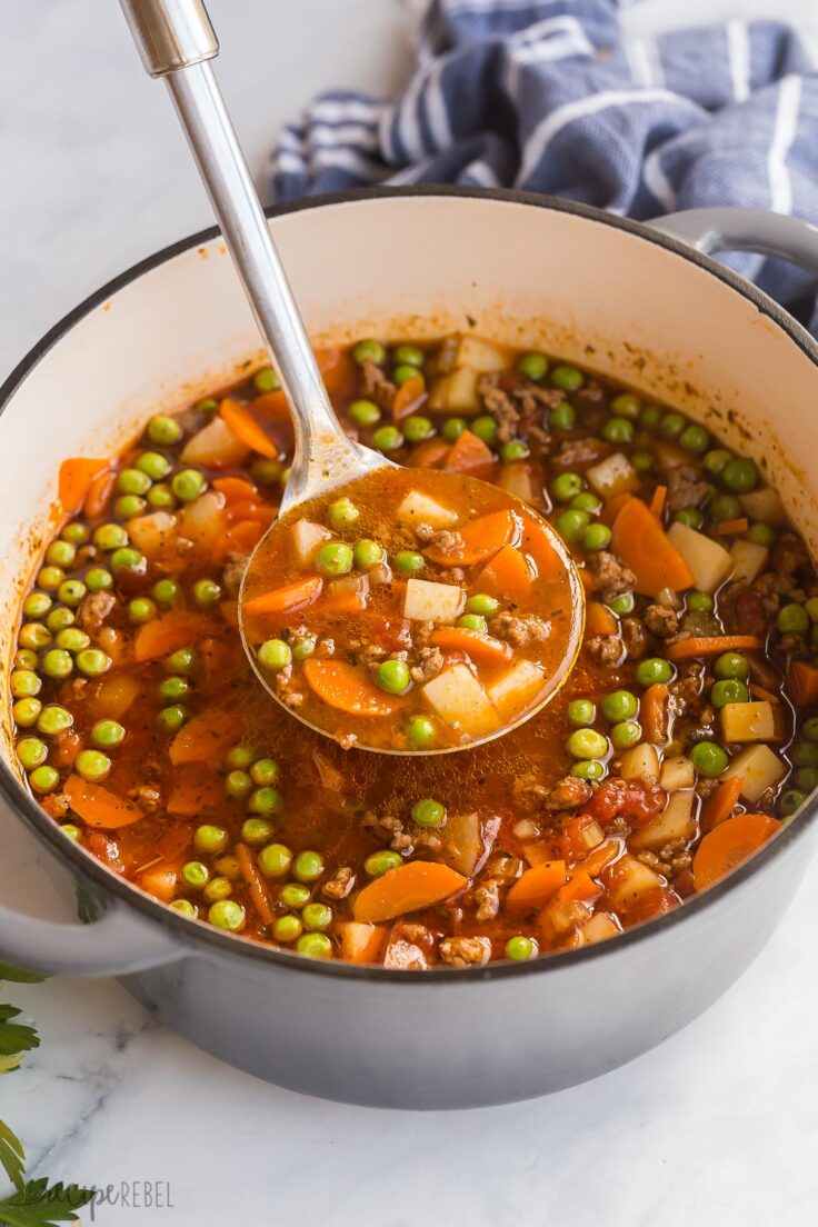 metal ladle scooping hamburger soup out of pot