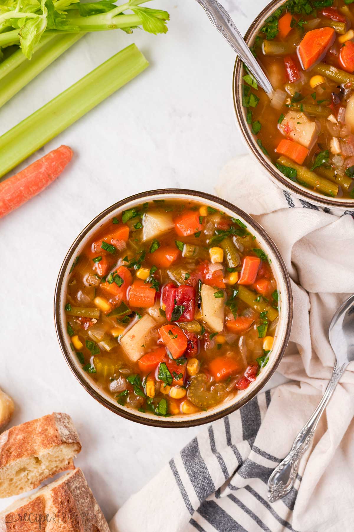 two bowls of instant pot vegetable soup with vegetables on the side