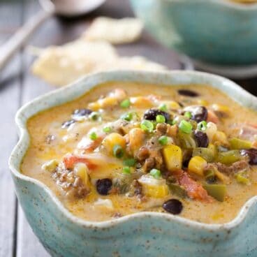 close up image of nacho soup in blue bowl