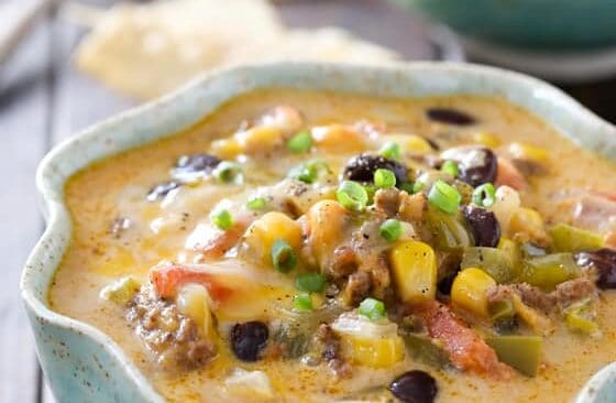 close up image of nacho soup in blue bowl