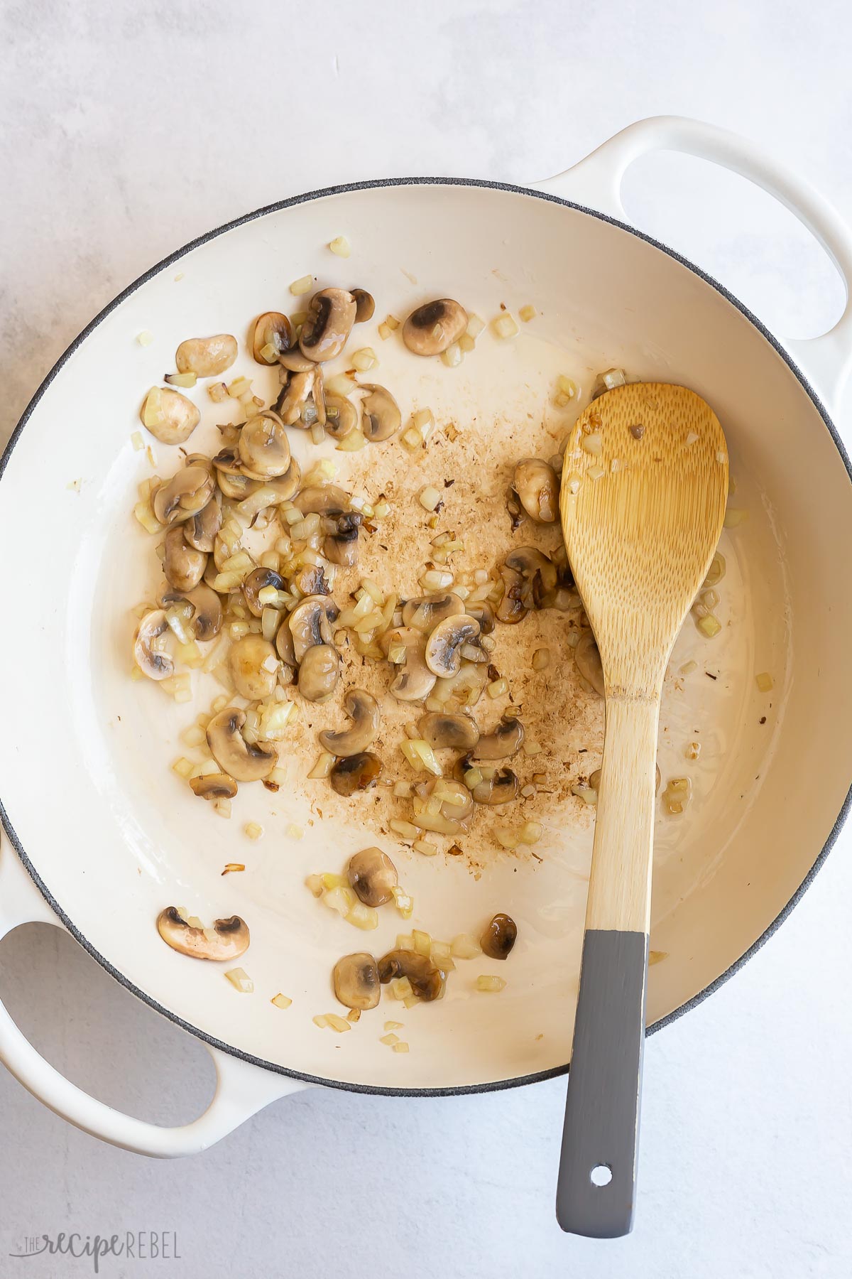 sauteeing mushrooms in white braiser.