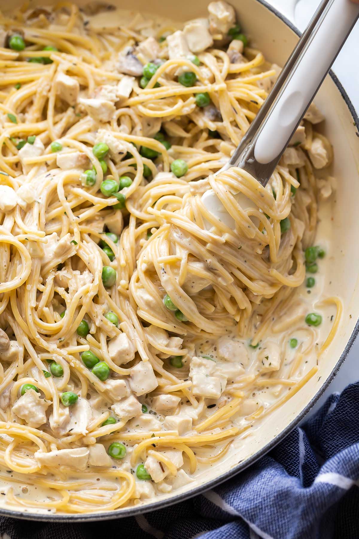 close up image of noodles twirled around tongs.