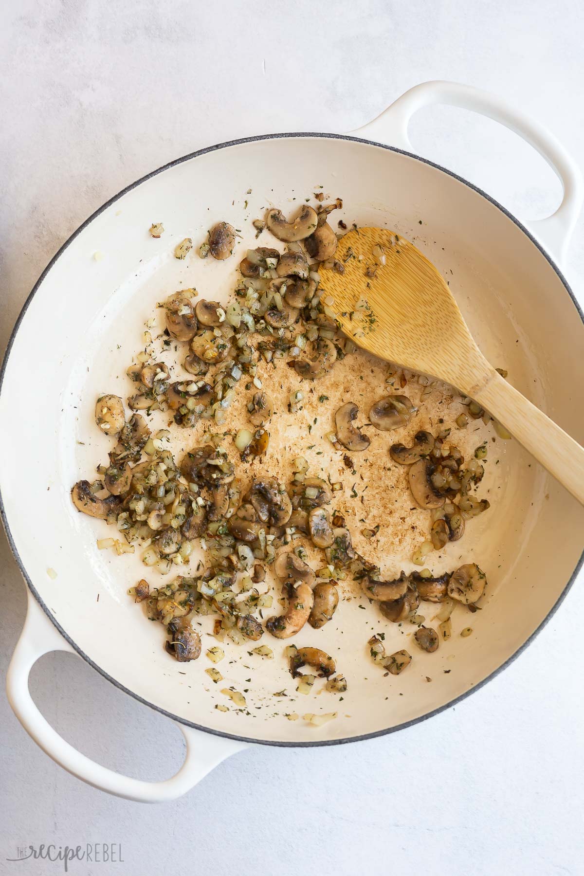 spices and herbs added to mushrooms in pan.