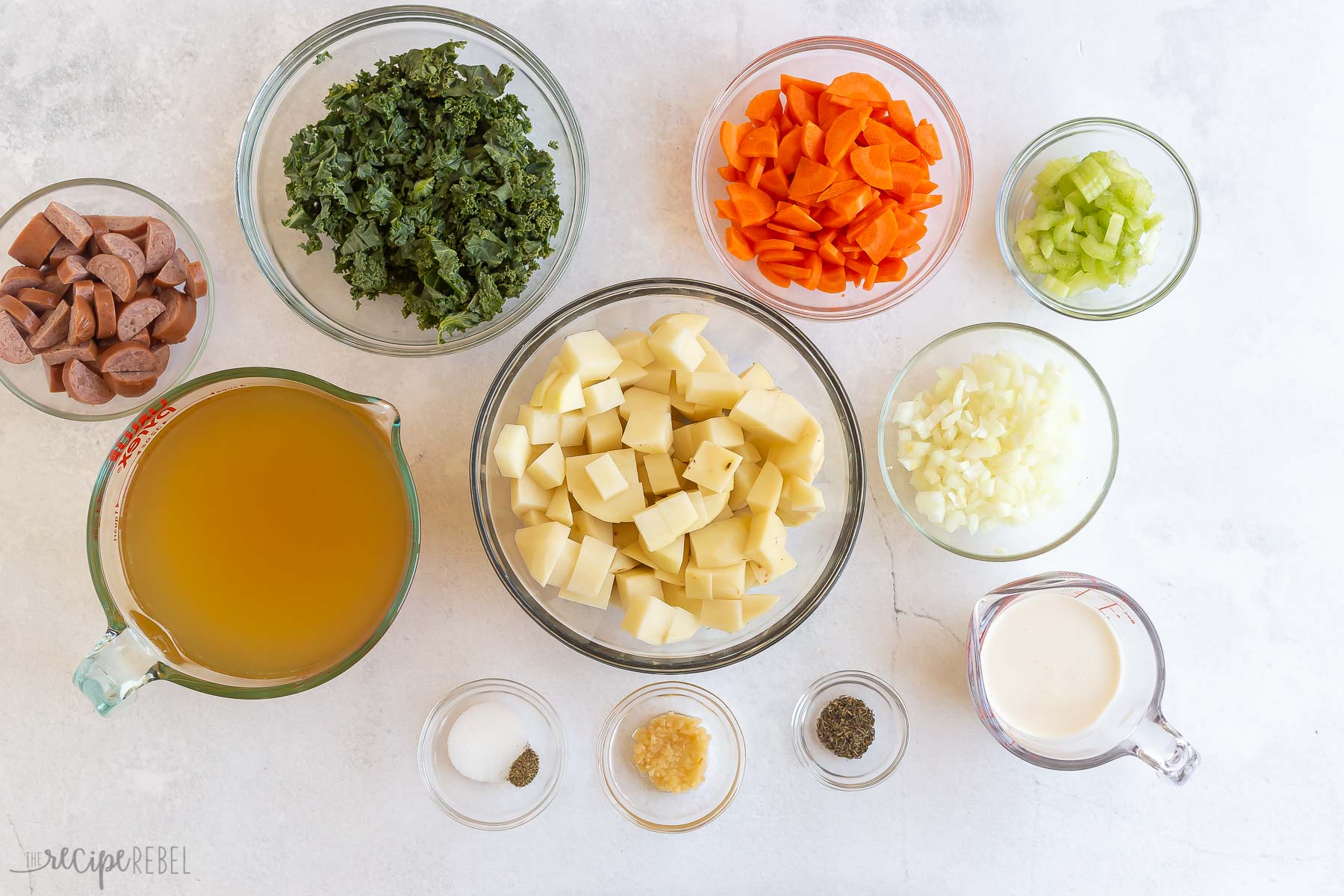 ingredients needed for sausage potato soup on white background.