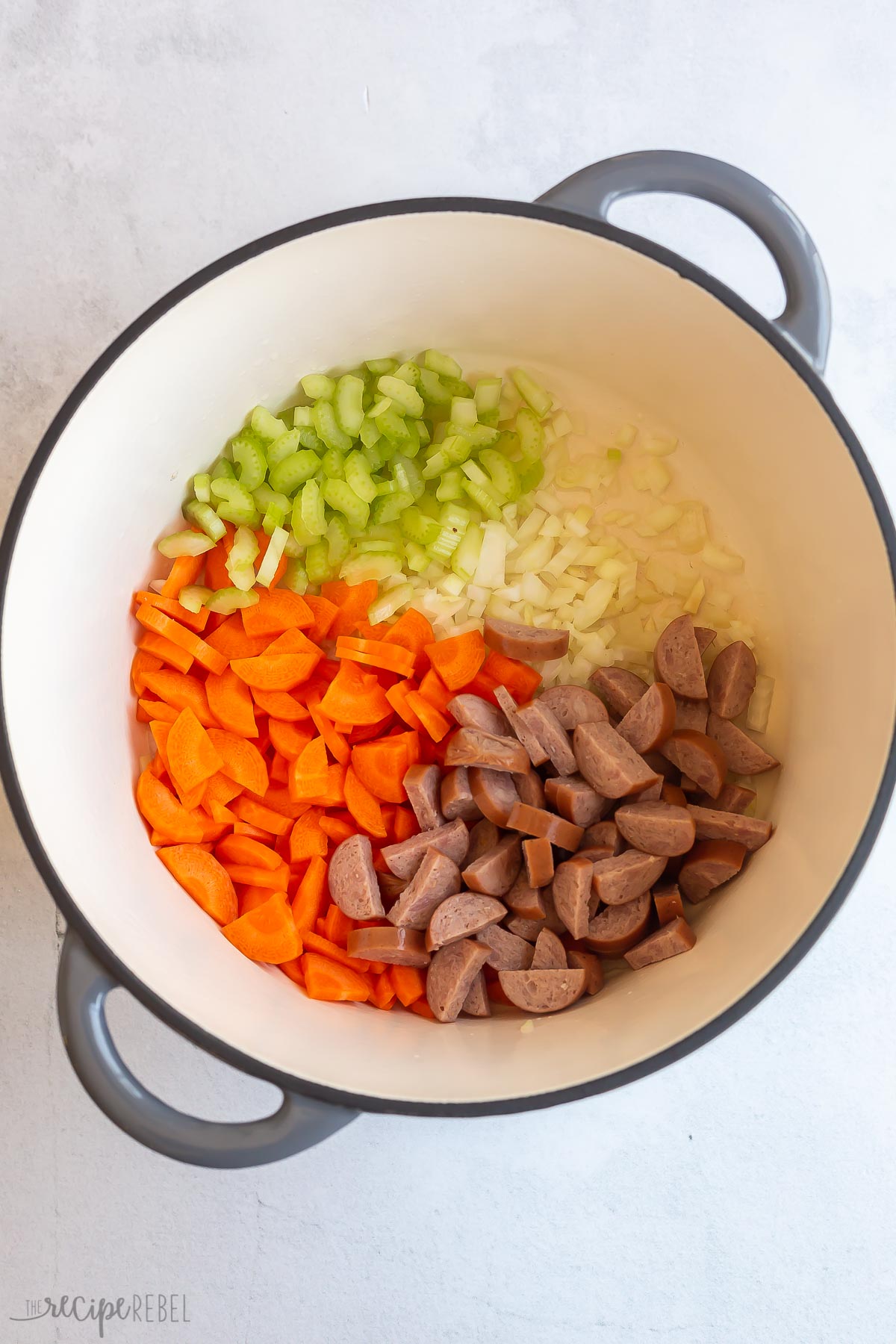 vegetables and sausage sauteeing in large dutch oven.