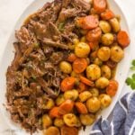 overhead image of shredded pot roast and potatoes and carrots on large white platter