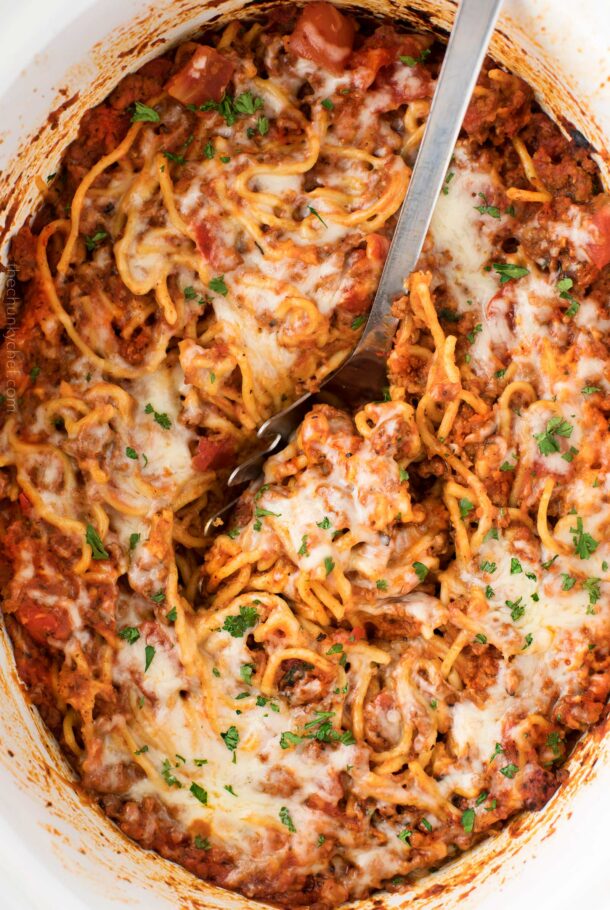 crockpot spaghetti casserole close up with metal spoon stuck in