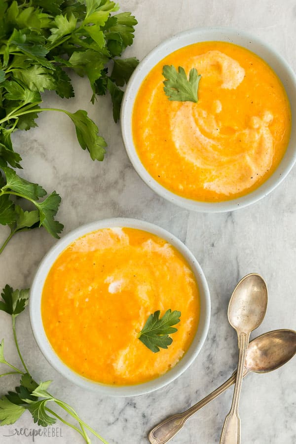 zuppa di carote in ciotole su marmo grigio con contorno di prezzemolo fresco