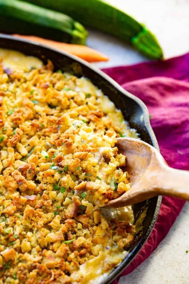 zucchini sausage casserole in cast iron skillet with wooden spoon stuck in