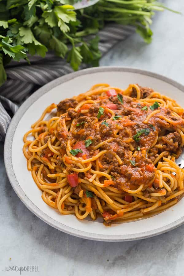 instant pot spaghetti healthy close up on grey and white plate with grey towel and fresh parsley in the background