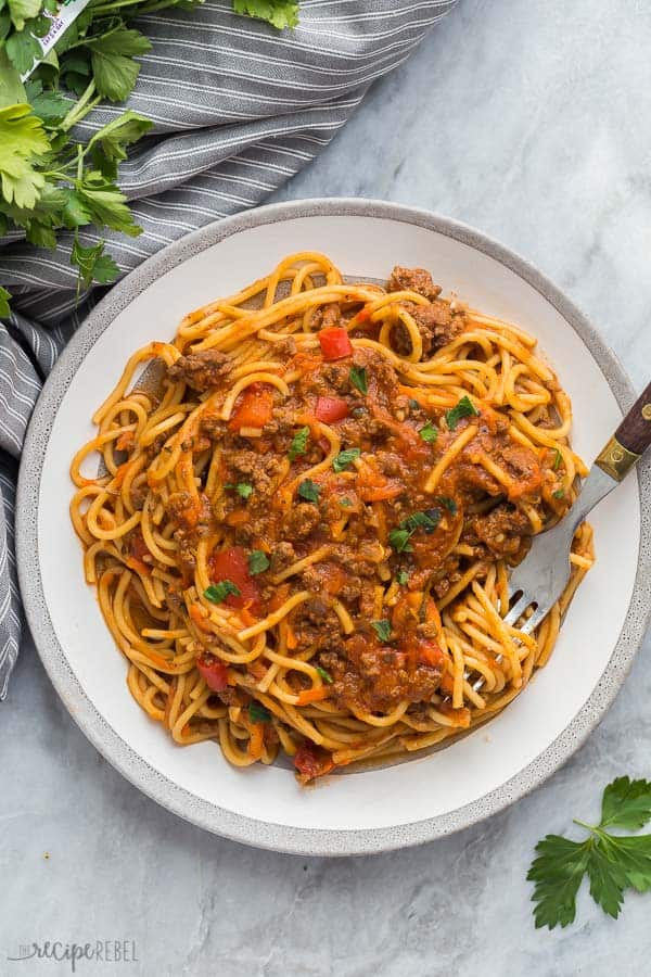 instant pot spaghetti on grey plate with fork stuck in noodles on grey marble background