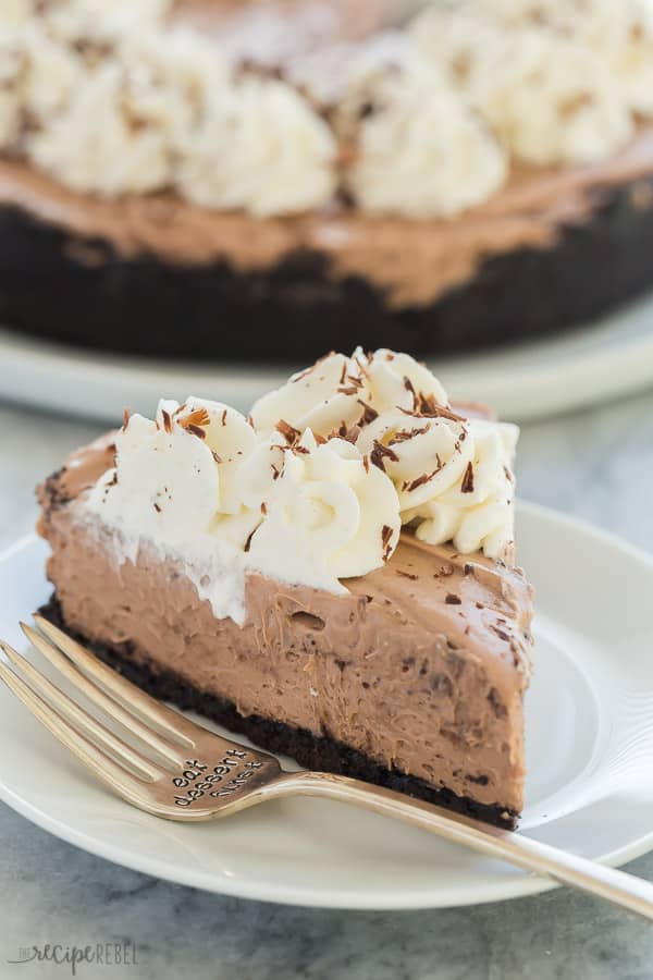 slice of no bake chocolate cheesecake on white plate with fork on the side