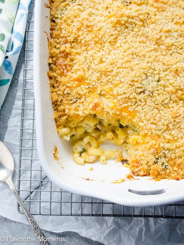 overnight mac and cheese casserole in white baking dish with a scoop missing from the corner