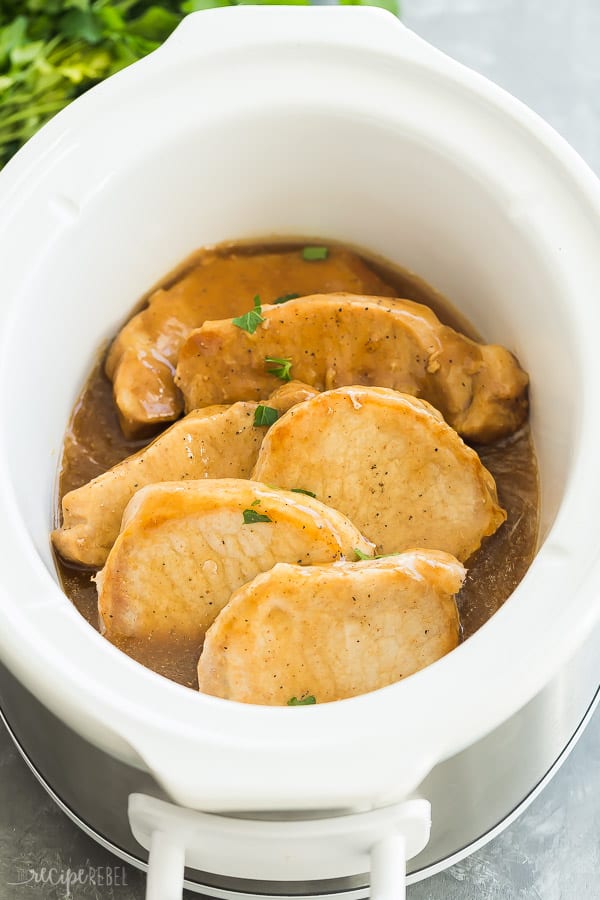 These EASY Crockpot Meals are perfect for those busy weekdays when it's a struggle to get dinner on the table, cozy and comforting for cooler days, or light and fresh for summer days. There's something for everyone! Crockpot pasta, soups, tacos, slow cooker ribs, pork, chicken or beef. TONS of easy crockpot dinners. #crockpot #slowcooker #easyrecipe #recipe #recipes #dinner #cooking glazed crock pot pork chops in slow cooker with sauce and sprinkled with fresh parsley