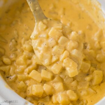 square image of spoon holding cheesy potatoes in crockpot