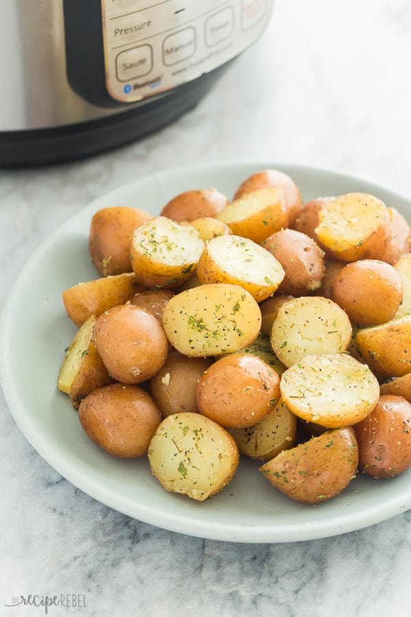 instant pot potatoes on blue plate on marble background with pressure cooker in the background