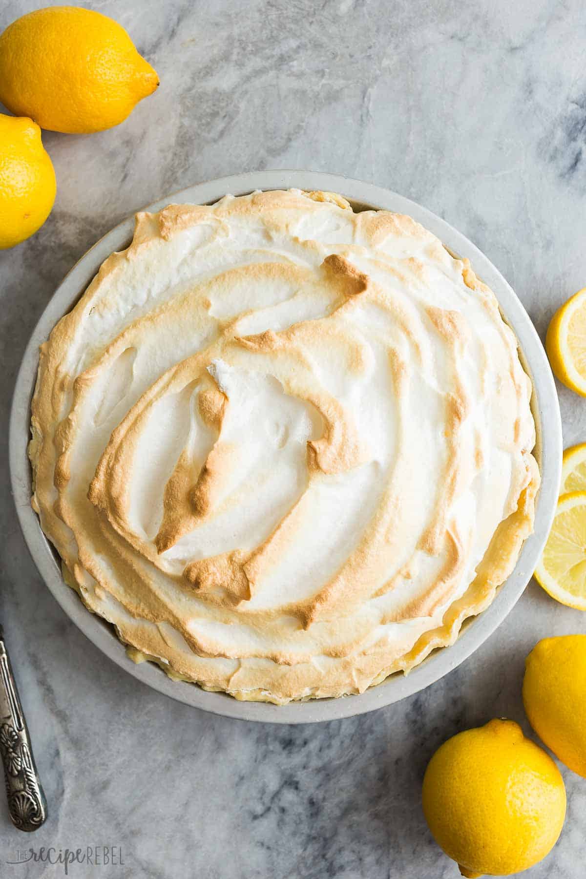 This easy Lemon Meringue Pie is cool, creamy and tangy -- the perfect dessert for Easter, spring or any occasion! Go totally homemade or take some shortcuts if you're short on time. #lemon #pie #dessert | dessert recipes | pie recipes | easter pie | easter dessert | lemon desserts | how to make meringue | how to make pie | lemon curd overhead image of full lemon meringue pie not yet cut.