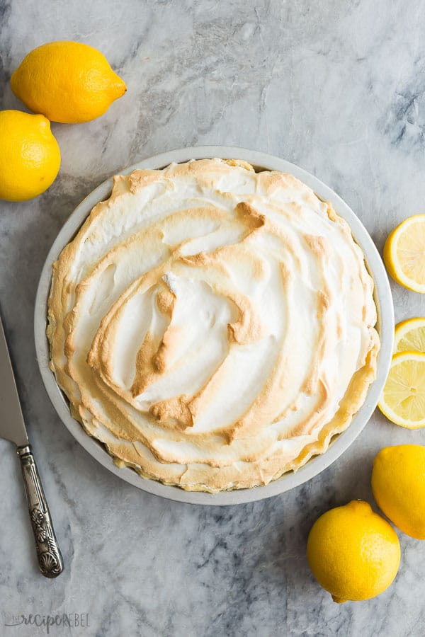 lemon meringue pie overhead with whole lemons on the side 