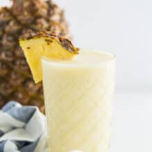 pineapple smoothie in glass with pineapple slice