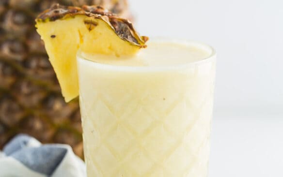 pineapple smoothie in glass with pineapple slice