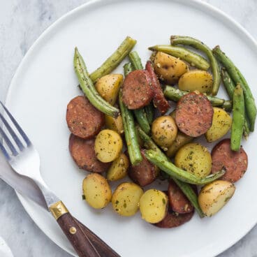 one pan sausage potatoes and green beans on white plate