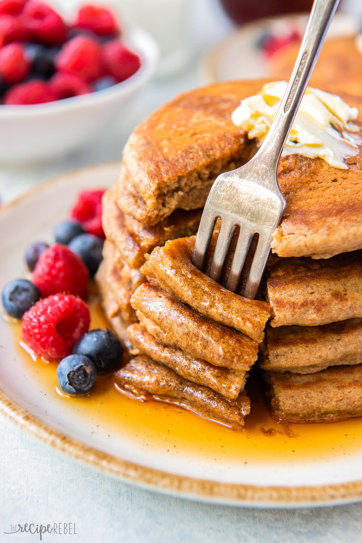 fork stuck into bite of four whole wheat pancajes